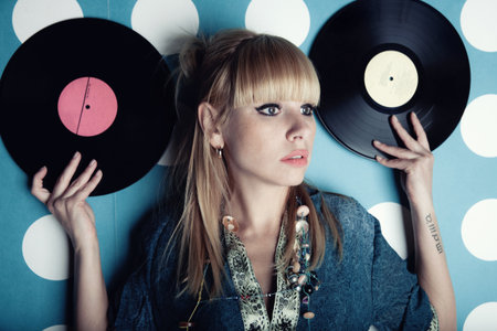 Portrait of a young beautiful woman with vinyl records in handsの写真素材