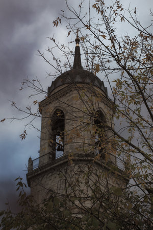Bell tower of the old Christian cathedral against  a dark autumn sky.の写真素材