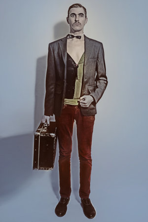 Studio portrait of Theater actor holds a suitcase in his handの写真素材