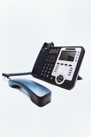 Black IP office phone closeup on white backgroundの写真素材