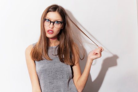 Studio portrait of a beautiful surprised young girl wearing eyeglassesの写真素材