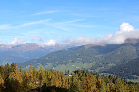 Sunny village is surrounded by tremendous mountainsの写真素材