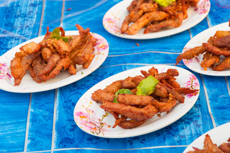 Thai fried pork jerky on plate on table sale at stall in marketの写真素材