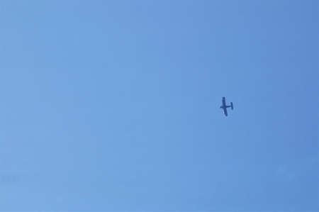 small airplane silhouette in clear blue sky