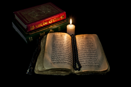 Quran books are illuminated by candle.の写真素材