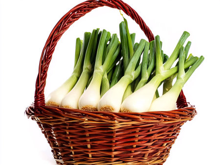 Fresh spring onions in a wicker basket isolated on a white backgroundの素材