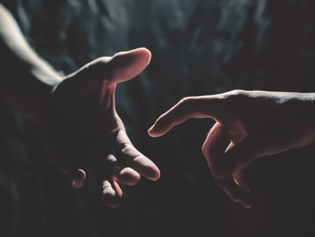 Two hands holding each other on dark background. Focus on fingers.の素材