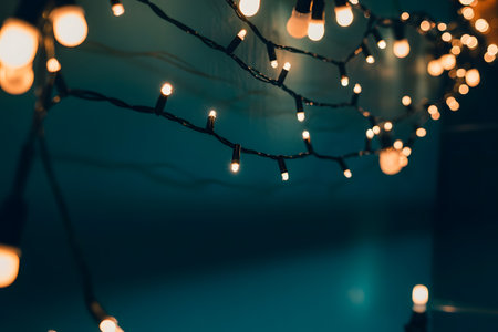 Warm glowing string lights create a cozy and festive atmosphere against a dark teal background, perfect for celebrations and holidaysの素材