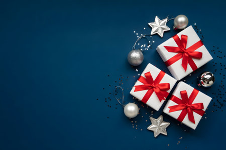 Elegant christmas gifts and silver ornaments on a dark blue background, perfect for holiday season greetingsの素材