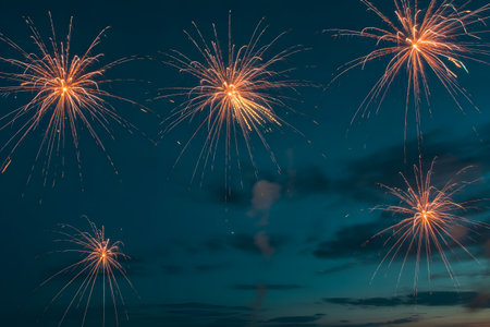 Bright and colorful fireworks exploding against a dark blue evening sky, celebrating a special event or holidayの素材