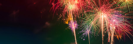 Vibrant and colorful fireworks light up the dark night sky, creating a spectacular display of celebration and joyの素材