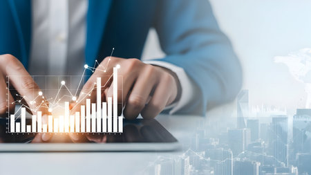 Business professional analyzes glowing financial data and charts overlaid on a modern city skylineの素材