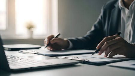 Business professionals collaborating and reviewing documents in a modern office settingの素材