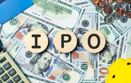 IPO text in wooden circle on Banknotes background, credit card, piggybank, calculator. Initial...