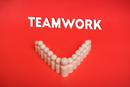 Teamwork, Cooperation, Business Success, Leadership concept. Teamwork text on red background with wooden figure, Collaboration, unity, Group of Employees, Driving, Success, Innovative Strategy Supportの写真素材