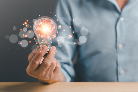 Business man holding Light bulbs with futuristic Brain inside. Innovative technology and creativity idea concept.の写真素材