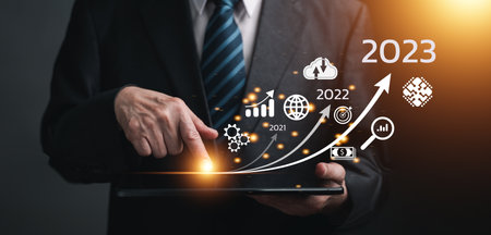Businessman touching on tablet, line for increasing arrow from 2022 to 2023 for new business,...
