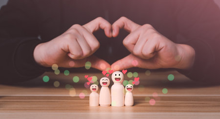 Wooden figures of family members, Family relationship, family love symbol, family closing concept, real estate insurance and investment, family business ideas with Hand heart Symbol.の写真素材