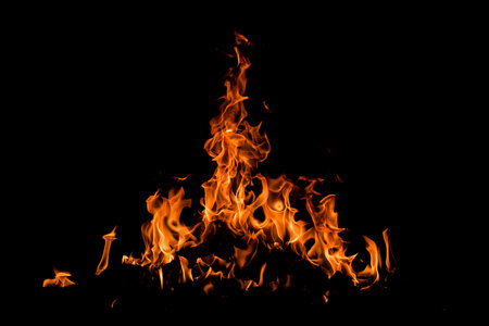 Fire over black background. Fire sparks background. Abstract dark background. Texture of fire on...