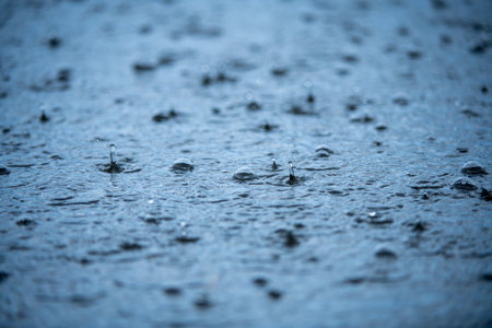 Raindrops background. Rain. Falling raindrops. Water drop splash. Abstract shape out of the water. Raining outside. Water texture.の写真素材