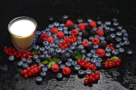 Background of fresh berries. Berry fruit with glass of milk. Breakfast. Blueberries, blackberries and raspberries. Vitamins in natural products. Berries.の写真素材