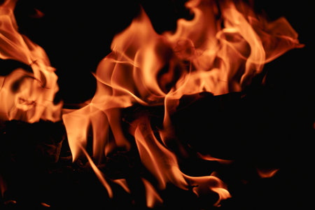 Fire over black background. Fire sparks background. Abstract blaze flames background. Burning fire....