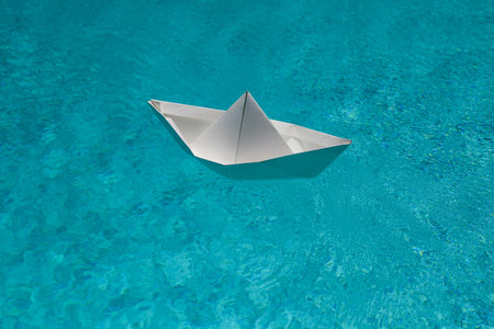 Traveling adventure. Sail boat. Summertime vacation. Paper boat in water. Paper boat sailing. Tourism and traveling, travel dreams vacation holiday, sailing adventure. Paper ship and ocean water.の写真素材