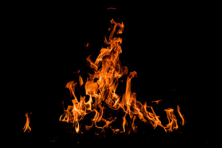 Fire over black background. Fire sparks background. Abstract dark background. Texture of fire on...