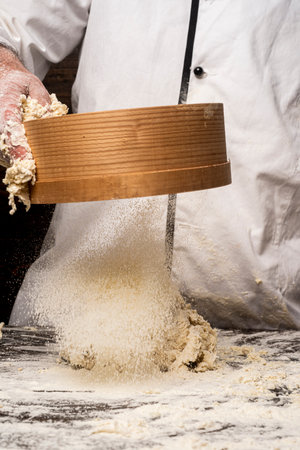 Hands baker with flour in kitchen. Hands covered in flours. Baker hands, flour and dough. Preparing dough for baking. Dough on white powder covered table. Hand flour.の写真素材