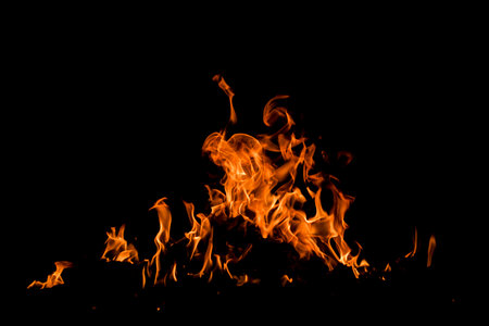 Fire over black background. Fire sparks background. Abstract dark background. Texture of fire on...
