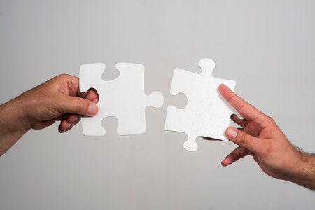Hand connecting puzzle. Man hands connecting puzzle piece. Closeup hands of man connecting jigsaw...