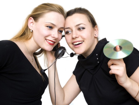 two girls attentively listen sounds from headsetsの写真素材