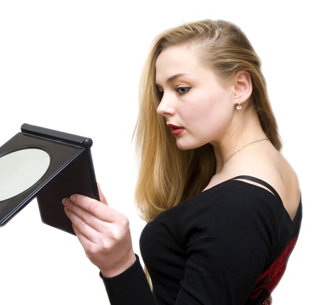 a young girl remedies a make-up before a mirrorの写真素材