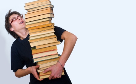 a student trying to keep a lot of their textbooksの写真素材