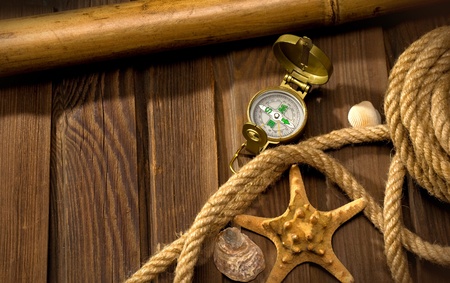old compass and rope on the background of old weathered woodの写真素材