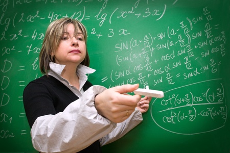 teacher shows the formula on the green chalkboardの写真素材