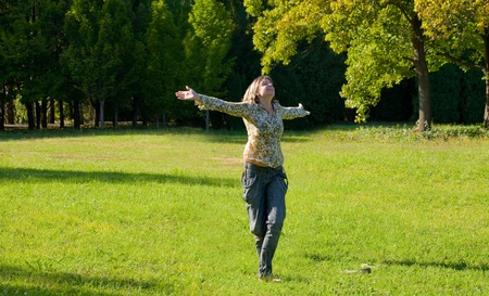 s.Carefree adorable girl with arms out in field.の写真素材