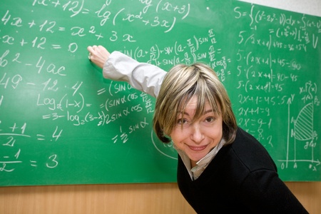  teacher is standing near blackboard in classroomの写真素材