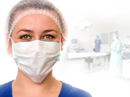 A portrait of a medical assistant while an operation takes place in the background.の写真素材