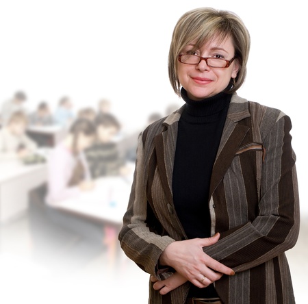 Happy teacher looking at camera with her students on backgroundの写真素材