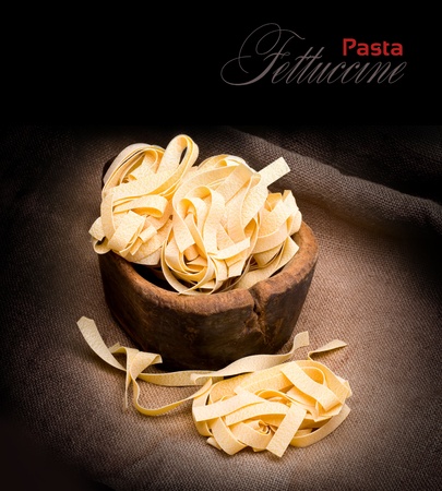 Italian pasta fettuccine nest  on dark  backgroundの写真素材