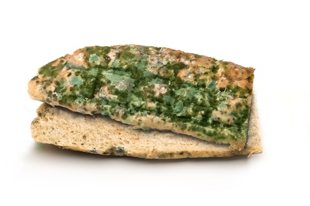 Mouldy bread loaf over a white background.の写真素材