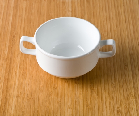 white cup of soup on a background of bamboo tableの写真素材