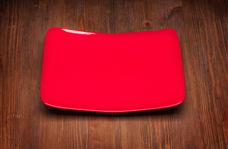 Red square empty dish on wooden backgroundの写真素材