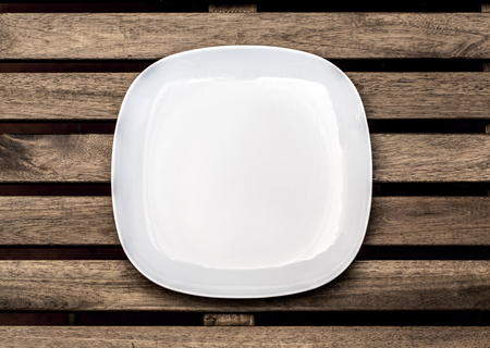 Empty white plate on wooden backgroundの写真素材