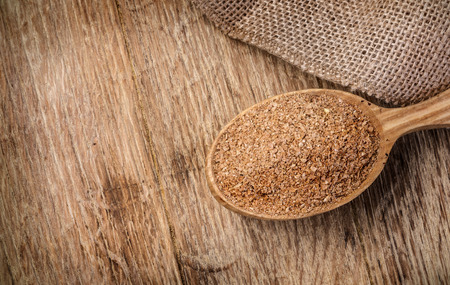 Wheat bran in wooden spoon Wooden planks background. Copy spaceの写真素材