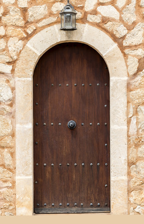 Arch of stone with closed wooden door.の写真素材