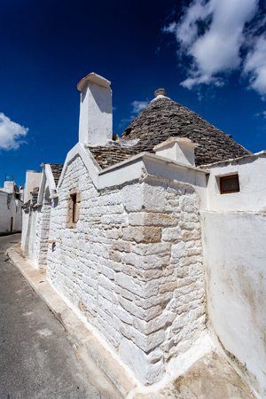 Group of Trulli with symbols, traditional old houses and old stone wall in Puglia, Italyの写真素材