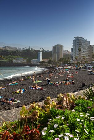 Tenerife, Spain December 25, 2018:people sunbathing on the city beach Santa Cruz, Tenerife, Spainのeditorial素材