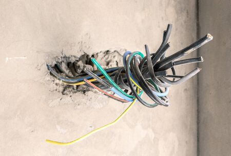 Unfinished electrical mains outlet socket with electrical wires and connector installed i in...